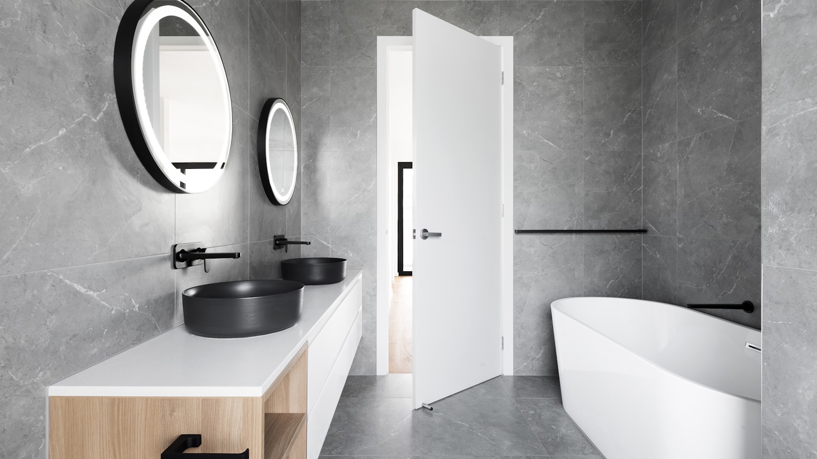 A grey stone-tiled bathroom with natural light