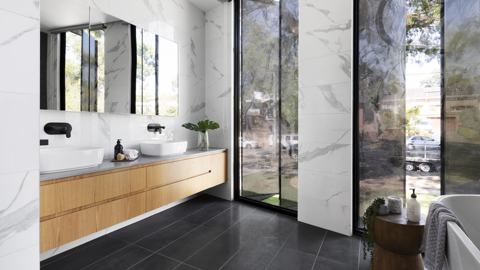 A bright finished bathroom with a marble vanity and large window