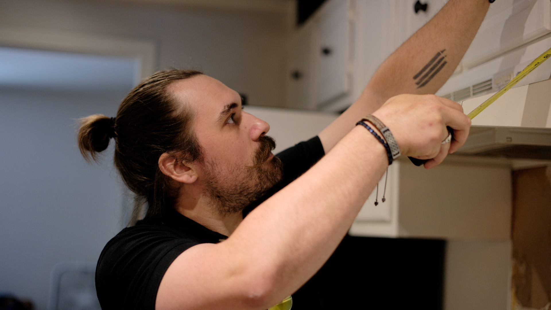 Trevor Todloski measuring cabinetry on a job site