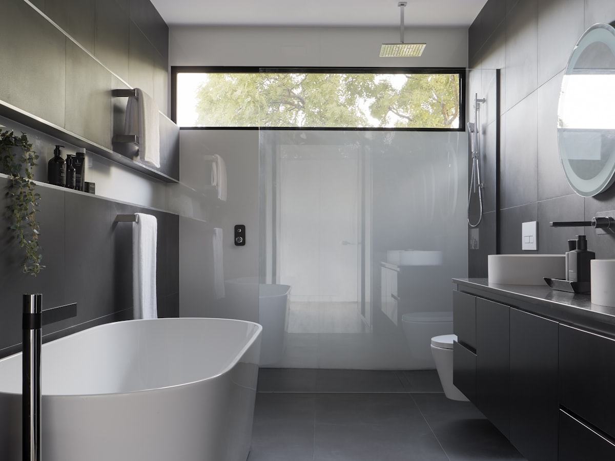 A finished modern bathroom with a glass walk-in shower and dark fixtures