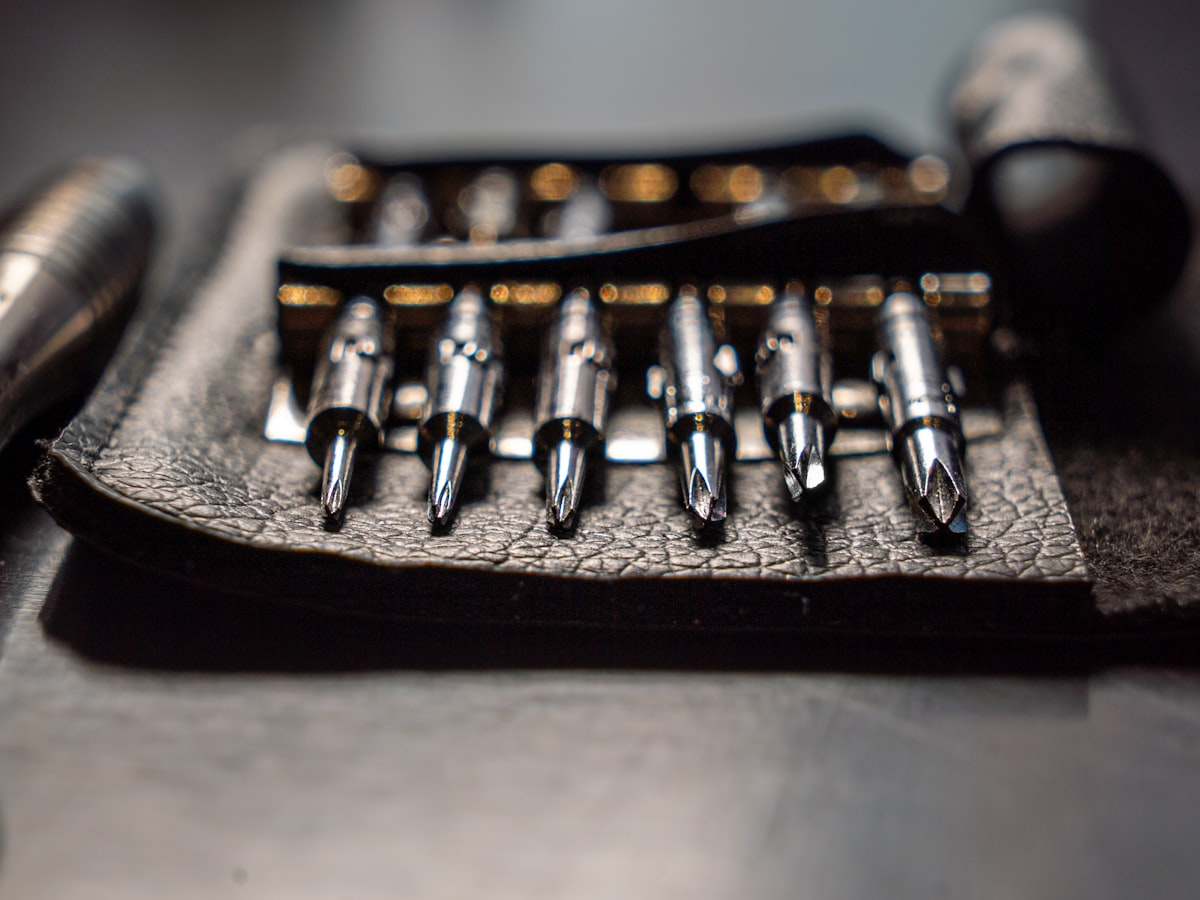 A set of driver bits laid out in a leather tool roll